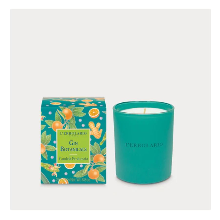 Candela profumata Gin Botanicals su tavolo in legno con erbe aromatiche